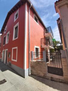 un edificio rosso e bianco con scale e balcone di Casa Orange 2 a Capodistria