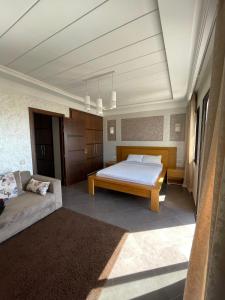 um quarto com uma cama e um sofá em Aglou center em Zaouia Sidi Ouaggag