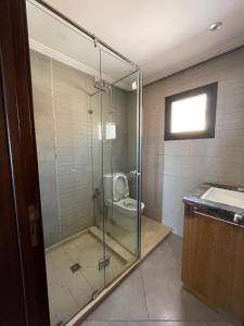 uma casa de banho com uma cabina de duche em vidro e um WC. em Aglou center em Zaouia Sidi Ouaggag
