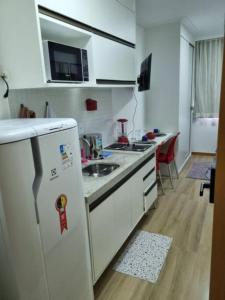 een kleine keuken met een witte koelkast in een kamer bij Studio, lindo, novo, praia! in Salvador
