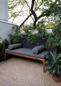 a couch sitting on the ground in a garden at Aposento Boutique Hotel in Mexico City