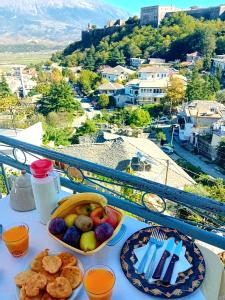 a table with two plates of food on a balcony at Guesthouse Çelo in Gjirokastër