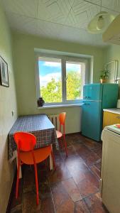 Una cocina con una mesa y dos sillas y un refrigerador. en Apartamentai 76, en Druskininkai 19 fotos más