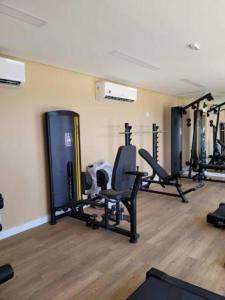 un gimnasio con varias cintas de correr y sillas en una habitación en Studio, lindo, novo, praia!, en Salvador