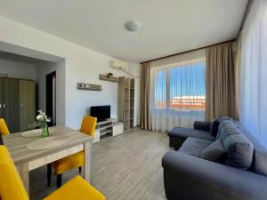 a living room with a blue couch and a table at Catalina Summerland Apartaments Mamaia Nord in Mamaia