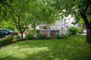 einen Hof mit Bäumen und Blumen und einem Gebäude in der Unterkunft Apartment Garden in Blagaj