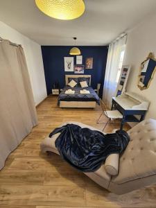 a bedroom with two beds and a couch in it at Le St Antoine - Centre Ville - Parking in Belfort