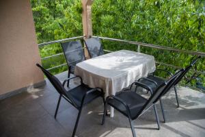 einen Tisch und 4 Stühle auf einem Balkon in der Unterkunft Apartment Garden in Blagaj