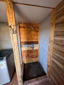 ein kleines Bad mit einem Waschbecken und Holzwänden in der Unterkunft Retiro Bajoestrellas in San Pedro de Atacama