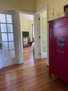 un soggiorno con porta rossa e pavimenti in legno di En el corazon del Cerro Alegre a Valparaíso
