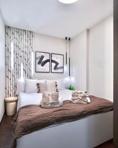 a white bedroom with a large bed with two pillows at One bed apartment at central location in Budapest in Budapest