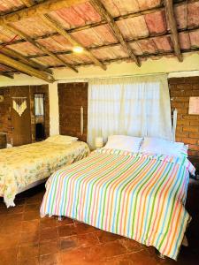 um quarto com duas camas num quarto em Cabaña Kinti Yuraq en Kinti Wasi em Cajamarca