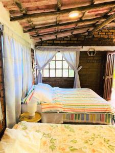 1 dormitorio con 2 camas y ventana en Cabaña Kinti Yuraq en Kinti Wasi, en Cajamarca