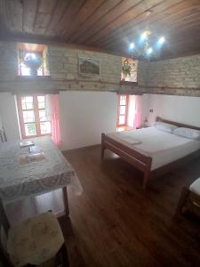Un dormitorio con una cama y una mesa. en Guesthouse Çelo, en Gjirokastra