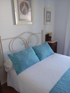 サンルーカル・デ・バラメダにあるLas Nievesのベッドルーム(青い枕のベッド1台付)