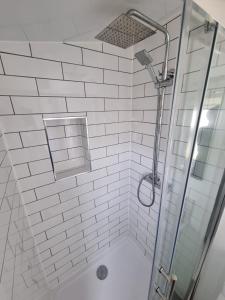 a white tiled shower with a glass shower backdoor at Alberta holiday park in Whitstable