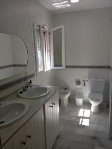 サンルーカル・デ・バラメダにあるLas Nievesのバスルーム(洗面台2台、トイレ、鏡付)