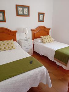 サンルーカル・デ・バラメダにあるLas Nievesのベッドルーム1室(ベッド2台、ナイトスタンド付きドレッサー付)