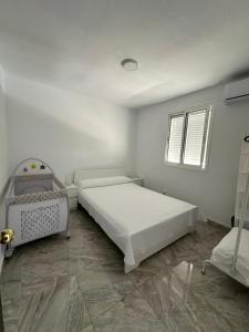 a white bedroom with two beds and a window at Vivienda en Arrecife de 4 habitaciones in Arrecife +15 photos