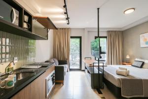 a hotel room with a bed and a kitchen at Meu Club Haas in Sao Paulo