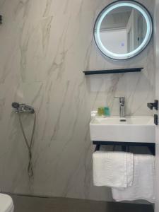 W łazience znajduje się umywalka i lustro. w obiekcie Sunshine Apartments and Rooms w mieście Nikiana