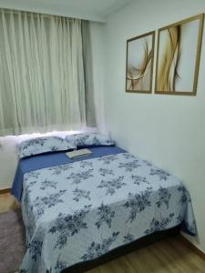 um quarto com uma cama com um cobertor azul em Studio, lindo, novo, praia! em Salvador