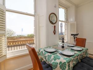 een eetkamer met een tafel en een raam bij The Aquamarine Sea View Apartment in Weymouth
