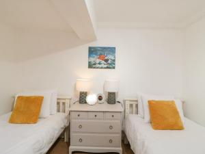 twee bedden in een kamer met witte muren bij The Aquamarine Sea View Apartment in Weymouth