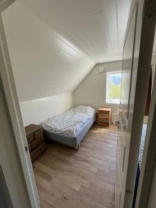 małą sypialnię z łóżkiem na poddaszu w obiekcie Feriehus og naust i idylliske omstendigheter w mieście Tjørvåg