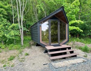 a small cabin with a staircase in the woods at Pod strání 3 in Kníničky
