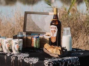 侯斯普瑞特的住宿－Maroelani Lodge- Greater Kruger Private Reserve，一瓶葡萄酒和一篮面包及牛奶