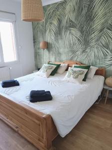 a bedroom with a large bed with two bags on it at Oasis au Chenal - Proche Plage in Grand-Fort-Philippe