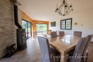 Le Refuge du Bois d'Amour في Arnières-sur-Iton: غرفة طعام مع طاولة ومدفأة