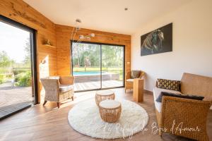 ein Wohnzimmer mit einem Sofa und einem Tisch in der Unterkunft Le Refuge du Bois d'Amour in Arnières-sur-Iton