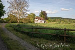 una cerca frente a una casa en un campo en Le Refuge du Bois d'Amour en Arnières-sur-Iton