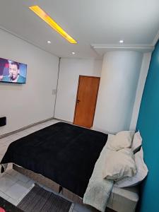 a bedroom with a bed and a painting on the wall at España Stay in Ciudad del Este