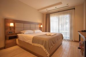 ein Schlafzimmer mit einem großen Bett und einem großen Fenster in der Unterkunft Sezz Hotels Spa Wellness Yalikavak Adult Only in Yalıkavak