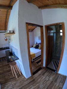 a room with a bedroom and a bed and a table at Chalés Vila Carrancas - Ao lado do centro com piscina, cozinha completa e muita tranquilidade in Carrancas