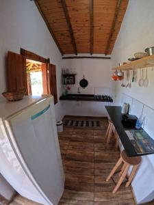 eine Küche mit einem Kühlschrank und einer Arbeitsplatte in der Unterkunft Chalés Vila Carrancas - Unidade Centro in Carrancas