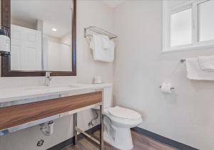 a white bathroom with a toilet and a sink at Pacific Shores Inn - Morro Bay in Morro Bay