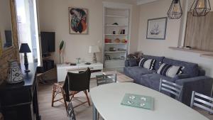 a living room with a blue couch and a table at Appartement Duplex 55m2 face à la mer in Luc-sur-Mer