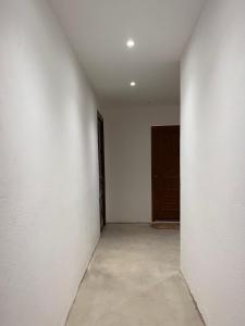 um quarto vazio com uma parede branca e uma porta em Mon cocon Ajaccien em Ajaccio