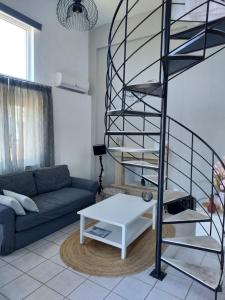 a living room with a spiral staircase and a couch at Jasmin & Olives in Érfoi +13 photos