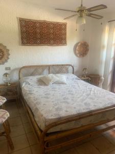 a bed in a bedroom with a ceiling fan at Corallo apartment in Cannigione