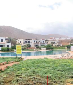 uma piscina com uma placa em frente a alguns edifícios em Aglou center em Zaouia Sidi Ouaggag