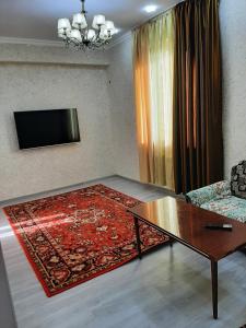 a living room with a coffee table and a television at Buxara apartment 