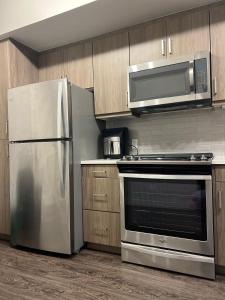 a kitchen with a stainless steel refrigerator and a microwave at 1 Bdr Apt in Irvine - Near John Wayne in Irvine