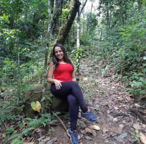 una mujer sentada en una roca en el bosque en FLAT 234 Hotel Pedra Rodeadouro, en Bonito