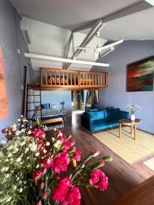 una sala de estar con un sofá azul y flores en You retreat, en Quy Thượng