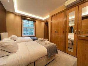 sypialnia z dużym łóżkiem i lustrem w obiekcie Luxe - Hyde Park - 2Bed 3Bath A/C + Lift w Londynie